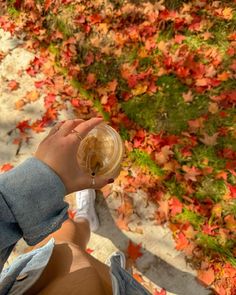 a person sitting on the ground drinking from a cup