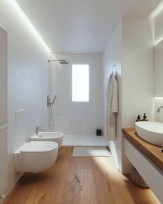 a white bathroom with two sinks and a bathtub