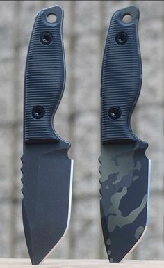 two knives with black handles are sitting side by side