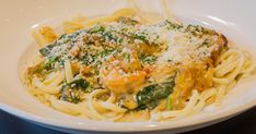 a white bowl filled with pasta covered in parmesan cheese