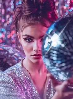 a woman holding a disco ball in front of her face