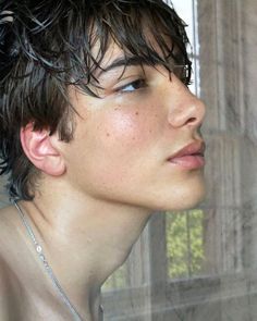 a close up of a person with wet hair and no shirt on, looking off to the side