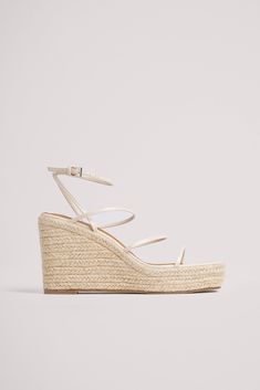 This heeled sandal features straps along the item. It has an adjustable ankle-strap fastening and a square toe. This heeled sandal features a wedge heel in jute. Measurements in size 39: Sole height: 3,5 cm 1.4 in. Heel height: 10 cm / 3.9 in. Natural Straw Heels With Wrapped Heel, Lace-up Platform Heels In Espadrille, Beige Wrapped Wedge Heel, Beach Lace-up Wedge Sandals With Wrapped Heel, Beige Woven Jute Sandals, Kd Shoes, Feminine Shoes, Wedge Espadrilles, Chic Shoes