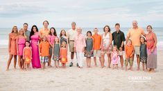 a large group of people standing on top of a sandy beach next to the ocean