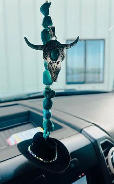 a car dashboard with a cow's head hanging from the dash board and beads on it