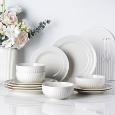 white dishes and vases with flowers in them