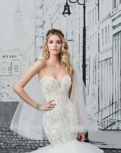 a woman in a wedding dress posing for the camera with her hands on her hips