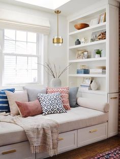 a living room filled with furniture and a fire place next to a brick wall in front of a window