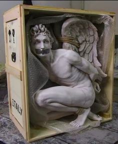 a statue of an angel sitting in a box