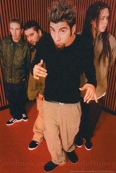 a group of young men standing next to each other in front of a red wall