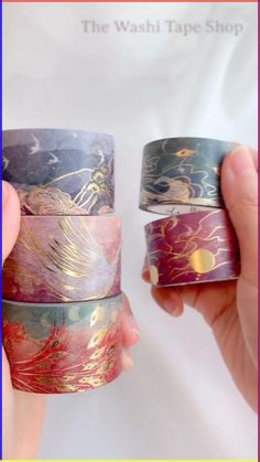 two hands holding three different types of washi tapes