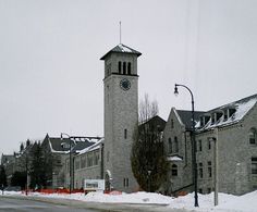 an old building with a clock tower on the side of it's face is covered in snow