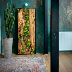 a painting on the wall next to a potted plant in a room with green walls