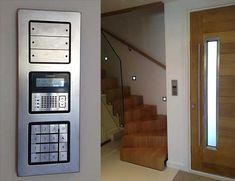 a phone is mounted to the side of a wall next to a stair case and door