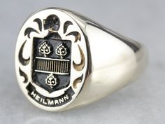 "This vintage gold ring is hefty and substantial, designed to be worn day in and day out for generations to come. The center is engraved deeply with a family crest. When stamped in a soft medium, such as sealing wax, this ring will create a decorative seal or stamp. This ring depicts three trees within a shield, with a botanical motif and knights helmet on top of the shield, this is the Heilmann family crest. Please note that this signet ring has its original monogram, unfortunately, this piece Vintage Gold Ring, Yellow Gold Sapphire Ring, Knights Helmet, Vintage Gold Rings, Top Measurements, Sealing Wax, Cameo Ring, Gold Signet Ring, The Shield