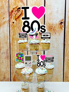 cupcakes are stacked on top of each other in front of a sign that says i love 80s