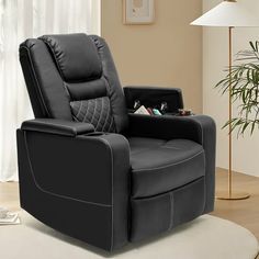 a black recliner chair sitting on top of a rug in a living room next to a lamp