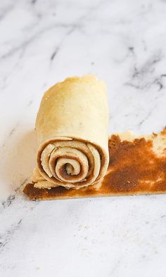 a rolled up tortilla sitting on top of a marble counter