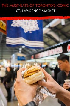 a person holding a sandwich in their hand with the words, the must - eats of toronto's iconic st lawrence market