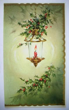 a lit candle is hanging from a light fixture with holly and red berries on it