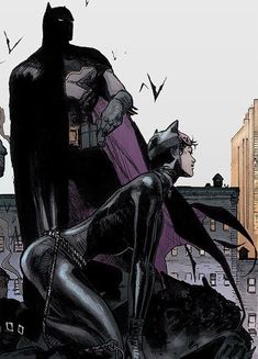 the batman and catwoman are sitting on top of a hill in front of city buildings