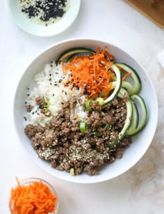 a bowl filled with rice, meat and veggies on top of a table