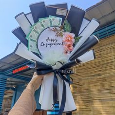 a person holding up a bouquet with flowers on it and the words happy engagement written on it