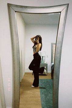 a woman standing in front of a mirror taking a selfie