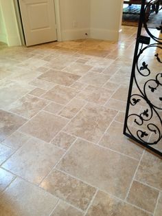 an entry way with tile flooring and wrought iron railing