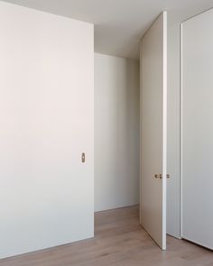 an empty room with white walls and wooden floors