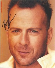 a close up of a person wearing a white shirt and smiling with an autographed on his forehead