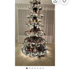 a christmas tree made out of tinsel with pictures on the top and decorations around it