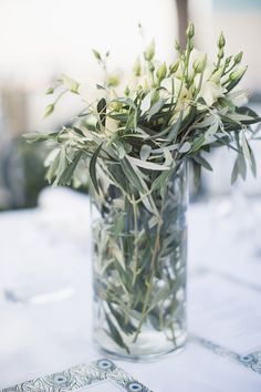 a glass vase filled with white flowers on top of a table