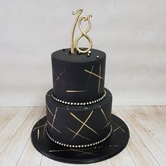 a black cake with gold decoration on top