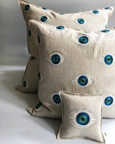 three pillows with blue eyes on them