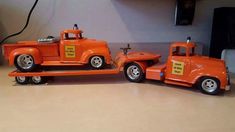 an orange toy truck and trailer on a table