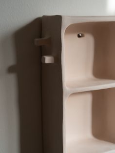 a white shelf with two shelves on the wall