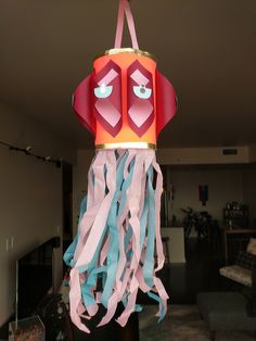 a paper lantern that has been made to look like a jellyfish hanging from the ceiling