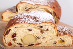 two pieces of bread with raisins and powdered sugar on top sitting on a cutting board