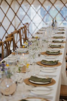 a long table set with place settings and plates