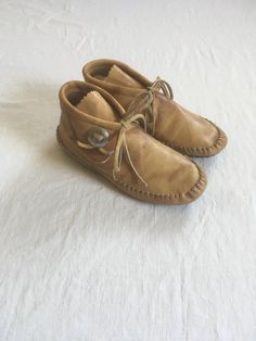 vintage 1970s women's moccasin shoes Taos light brown leather rubber sole cushion sole tie front concho  good vintage condition, light wear, insole cushion fiber has some shedding marked size 6 1/2 measures, insole-9 1/4" sole-9 1/2" width-3 1/8" Leather Moccasins With Woven Sole, Leather Round Toe Moccasins, Brown Low-top Moccasins With Leather Footbed, Brown Moccasins With Stitched Sole, Western Leather Moccasins With Rubber Sole, Bohemian Leather Moccasins With Rubber Sole, Vintage Round Toe Moccasins For Fall, Western Brown Moccasins With Leather Sole, Western Moccasins With Rubber Sole For Fall