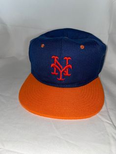 Vintage MLB New York Mets blue wool embroidered hat with orange bill and orange snapback. Excellent vintage condition! Casual Orange Hat With Embroidered Logo, Orange Baseball Cap For Sports Events, Orange Curved Brim Sports Hat, Orange Casual Baseball Cap For Sports Events, Orange Curved Brim Baseball Cap For Sports, Orange Sports Visor Baseball Cap, Orange Snapback Hats For Streetwear, Orange Snapback Hats For Sports Events, Casual Orange Baseball Cap For Sports Events