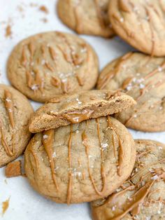 cookies with peanut butter drizzled on them are sitting on a white surface