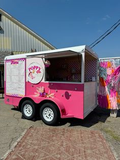 a pink food truck parked in front of a building