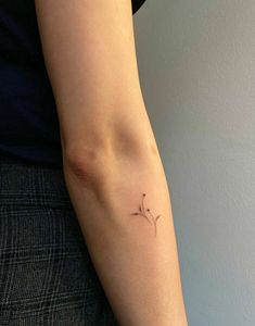 a woman's arm with a small tattoo on the left side of her arm