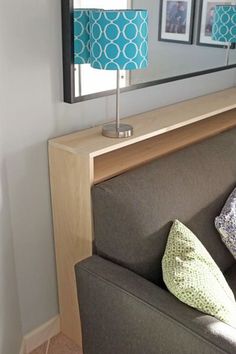 a living room with a couch, mirror and lamp