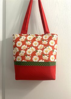 a red and white flowered bag hanging on a door