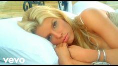 a blonde woman laying on top of a bed