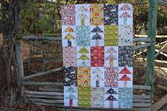 a quilt hanging on a fence in the woods