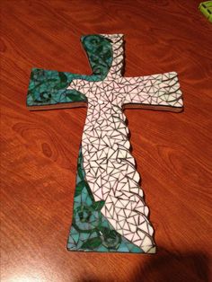 a wooden table topped with a stained glass cross